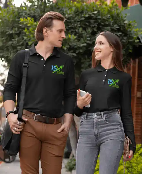 15X Business Solutions team members wearing branded black polo shirts, walking outdoors and having a conversation.