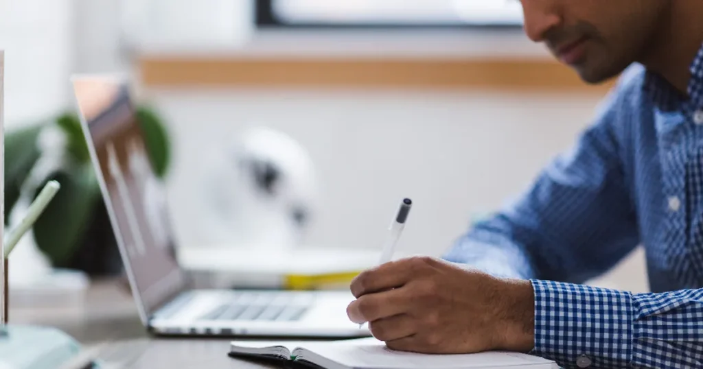 Small business owner at a laptop deciding if they need a CRM to replace paper notes