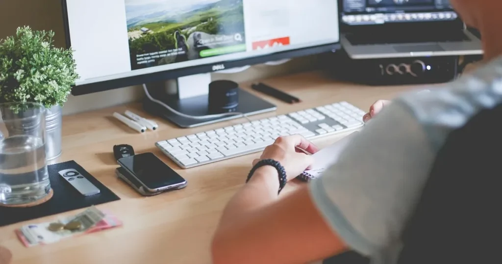 Person at a desk with a website on screen, planning a small business website cost
